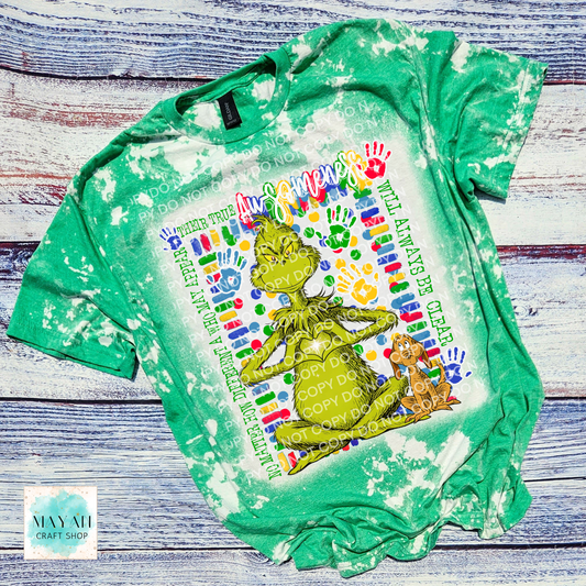 Green bleached t-shirt with a graphic design of a green creature and text on a wooden surface.