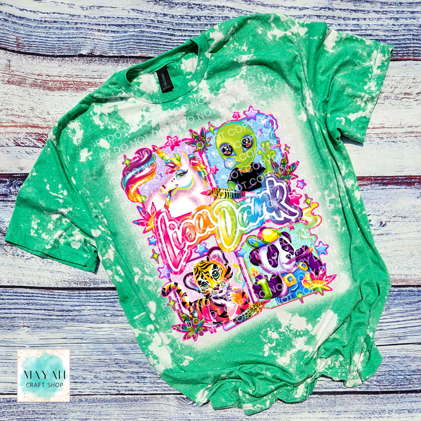 Green tie-dye t-shirt with colorful graphic design on a wooden surface