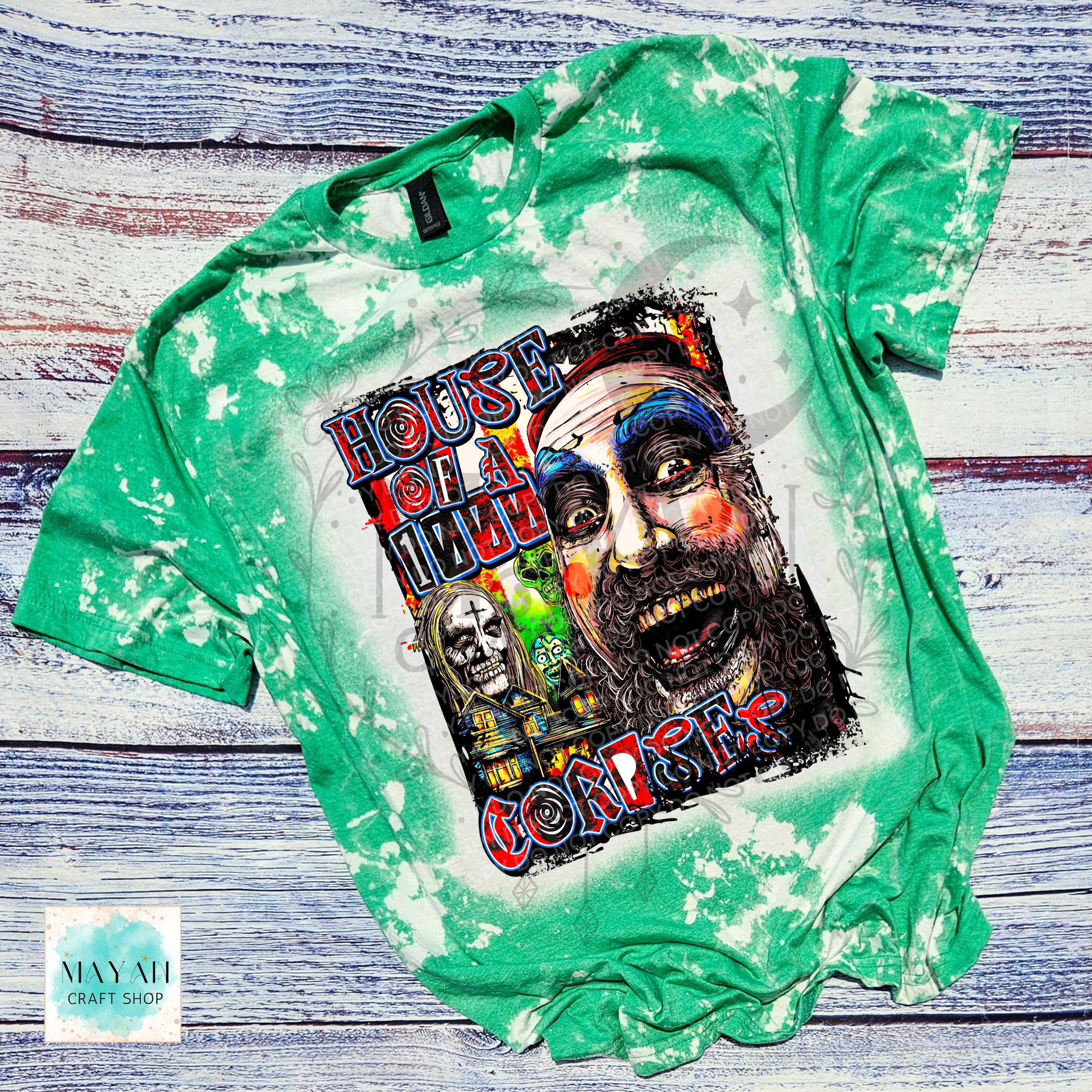 A green bleached graphic t-shirt laid flat on a rustic whitewashed wooden background. The shirt features a large, colorful graphic print on the front depicting a man's face, a skull, and a text.