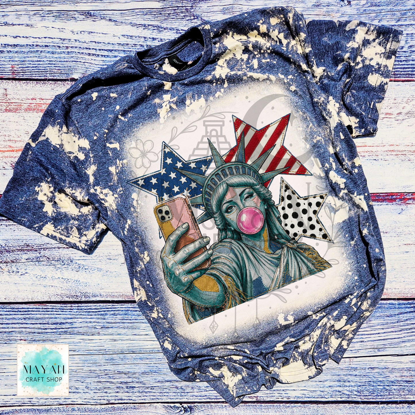 T-shirt with a graphic of the Statue of Liberty taking a selfie on a wooden surface.