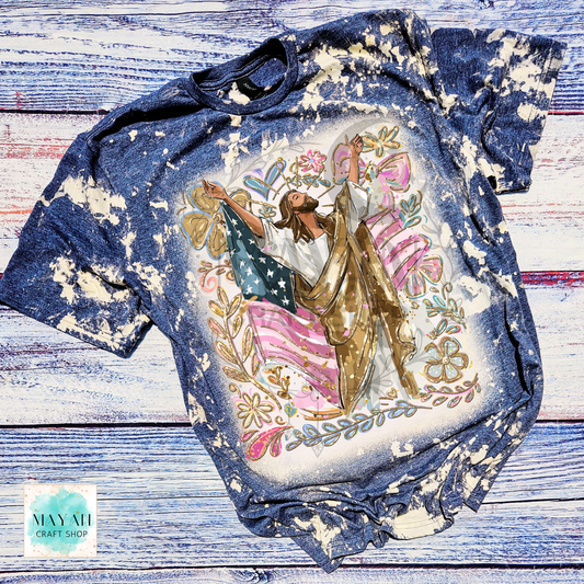Bleached t-shirt with a graphic design of a person holding an American flag on a wooden surface.