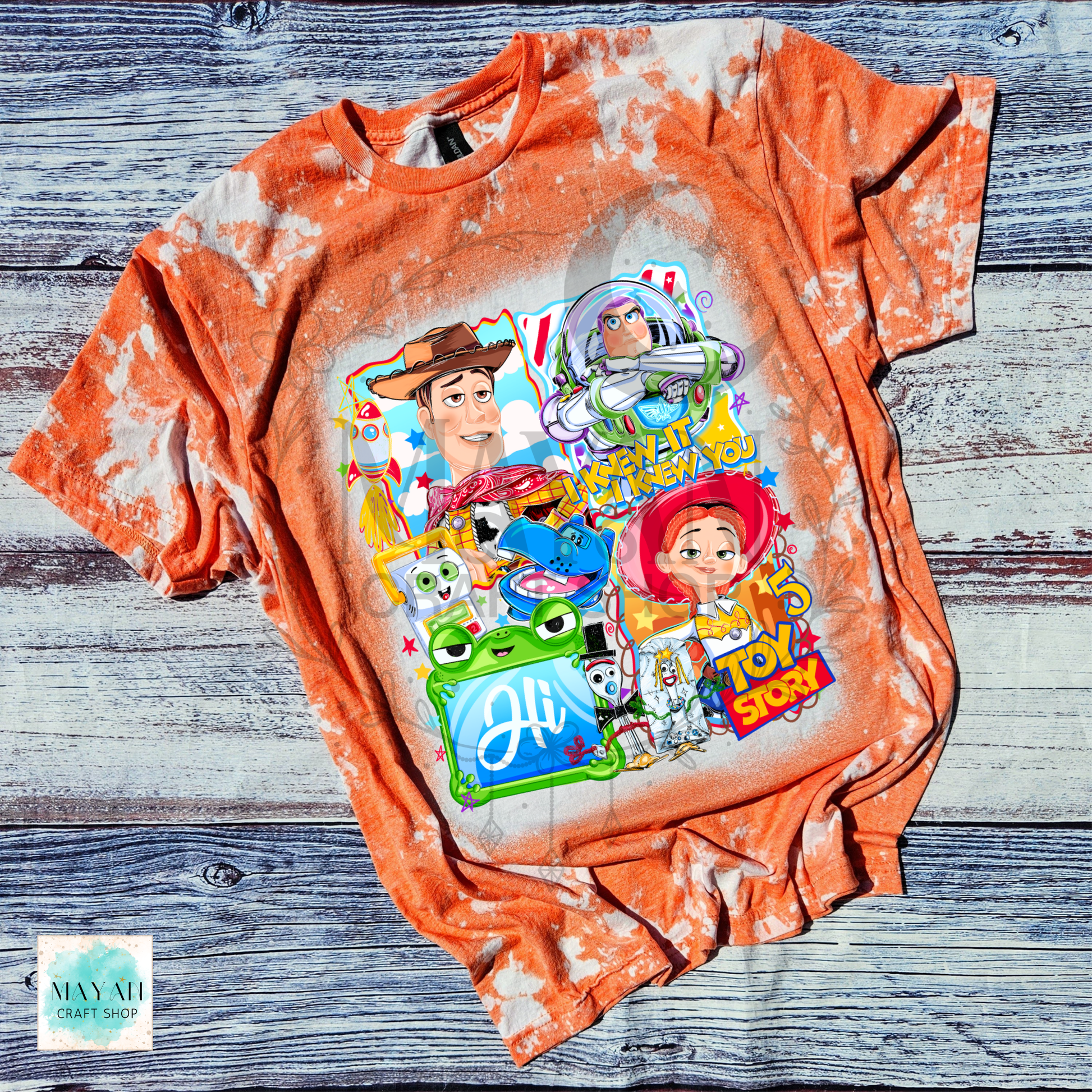 Orange tie-dye t-shirt with character graphics on a wooden surface