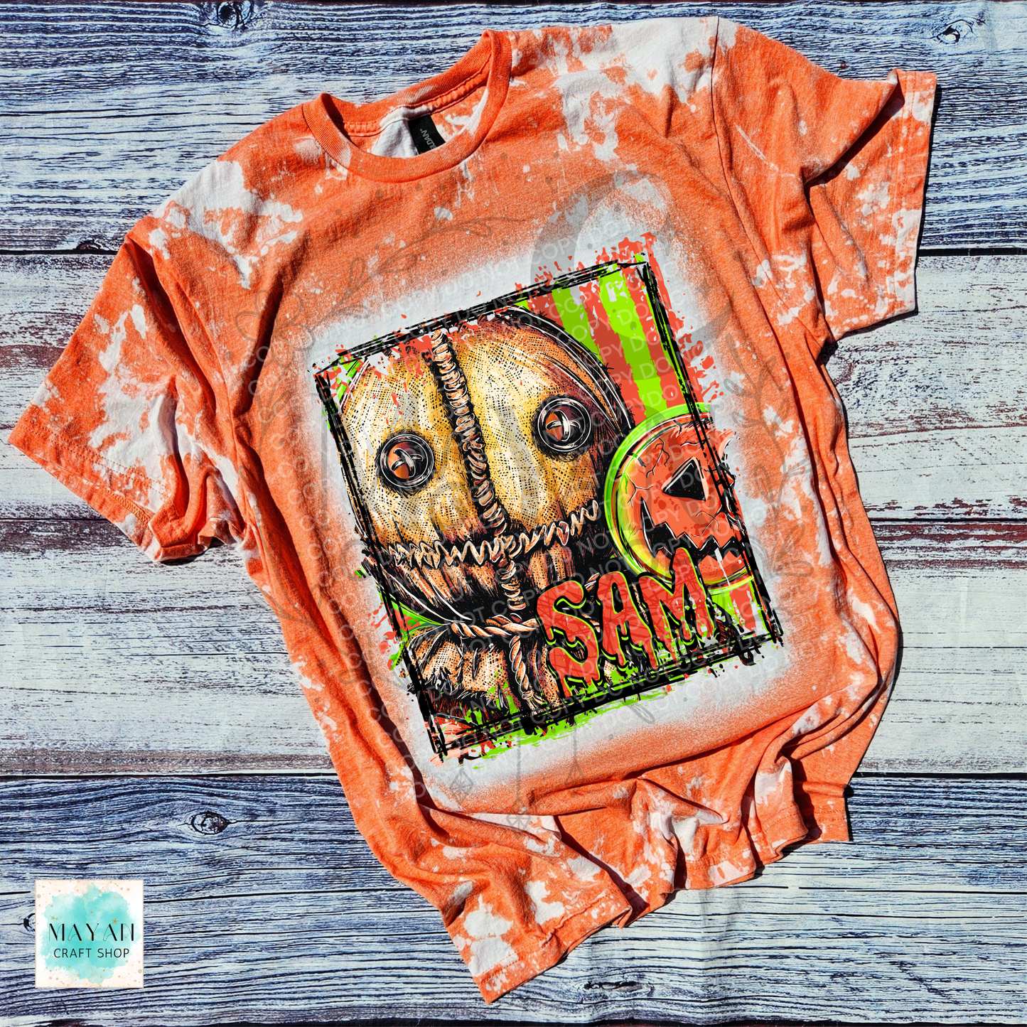 An orange bleached graphic t-shirt featuring a horror character design with a text on the front, laid flat on a rustic gray wood plank background.