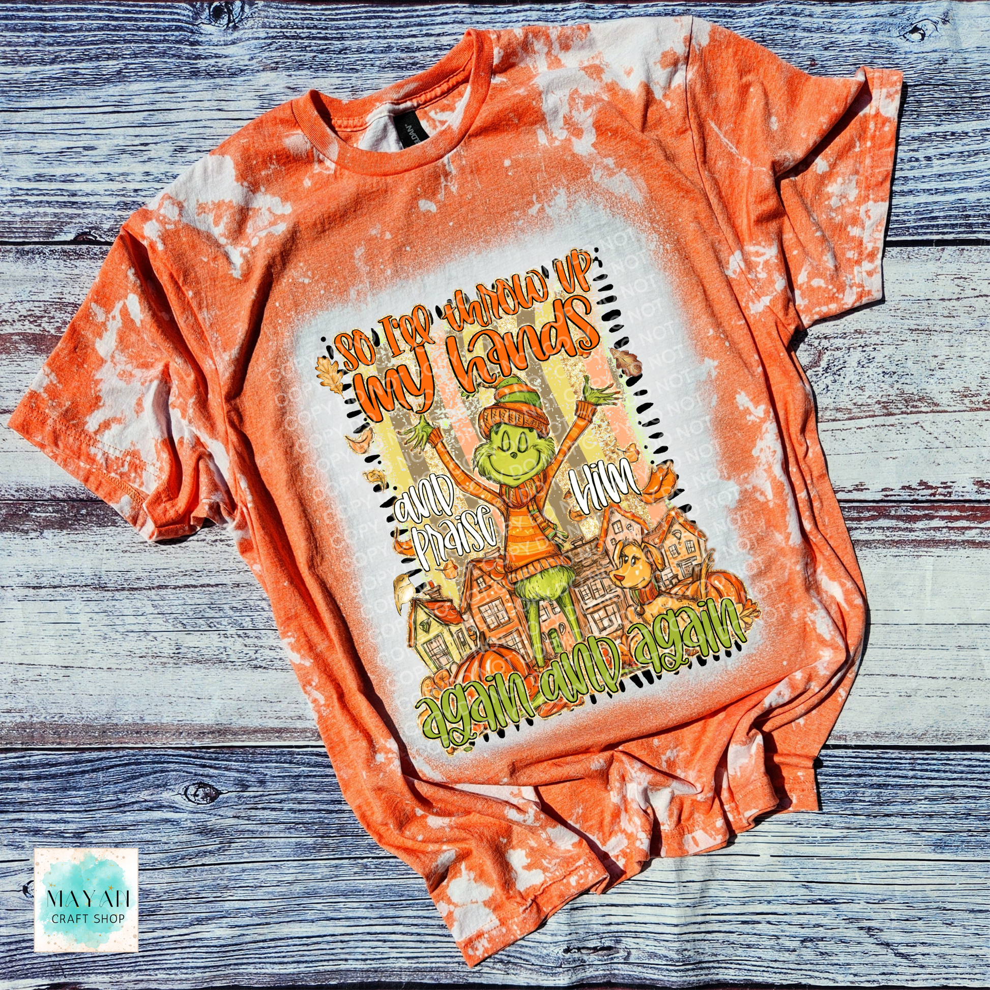 Orange tie-dye t-shirt with a graphic design on a wooden surface