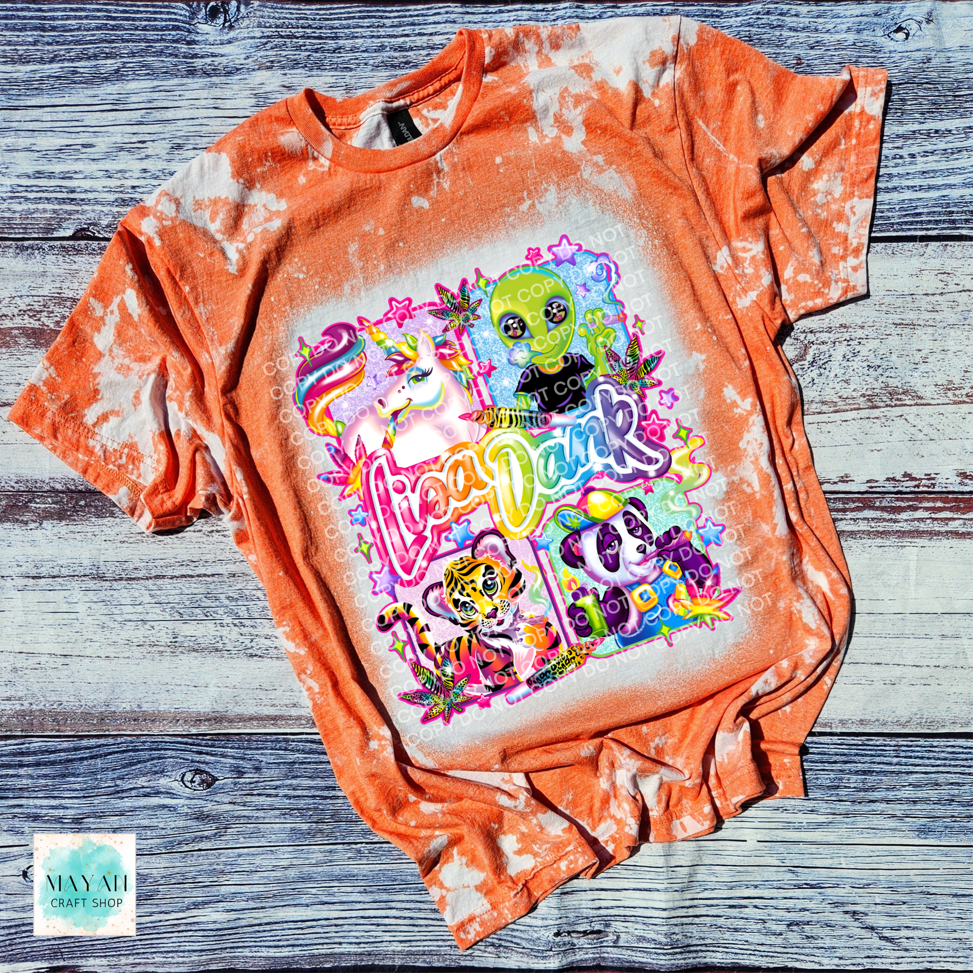 Dyed orange t-shirt with colorful graphic design on a wooden surface
