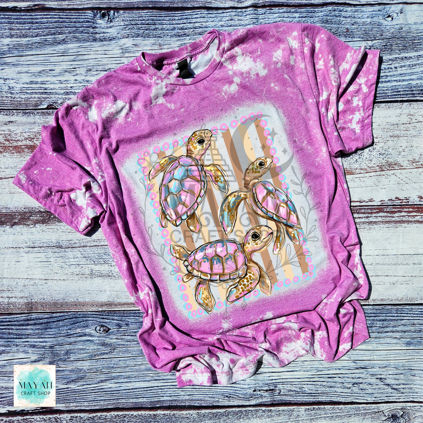 Heather orchid t-shirt with turtle design on a wooden surface