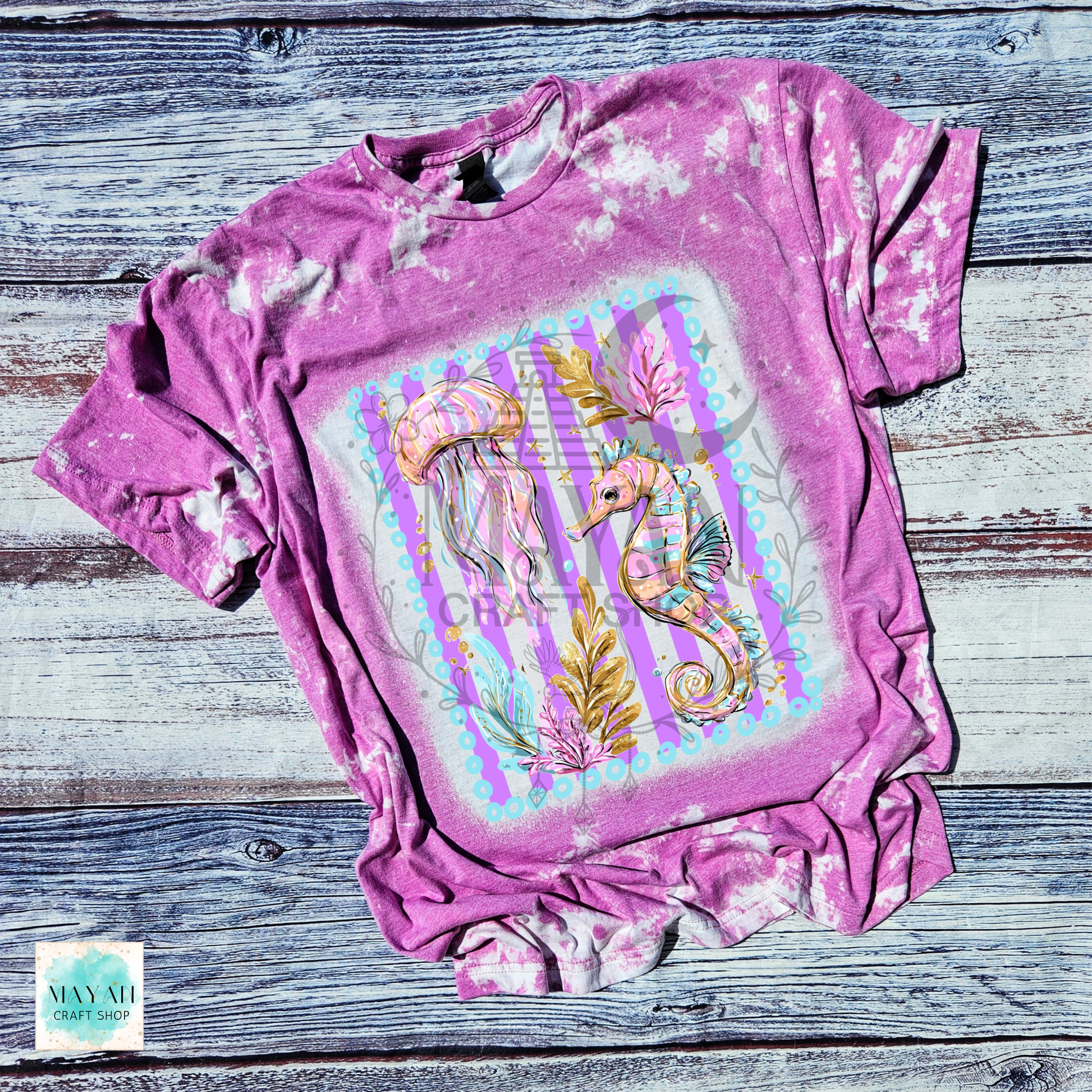 Orchid t-shirt with seahorse and jellyfish design on a wooden surface