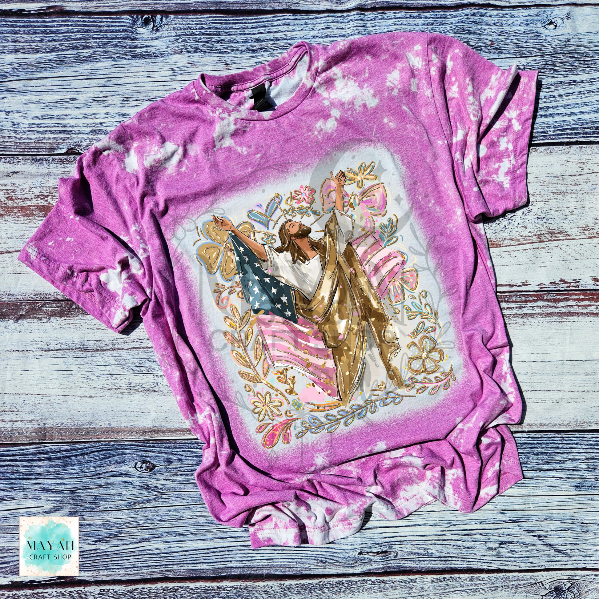 Pink tie-dye t-shirt with a graphic design on a wooden surface