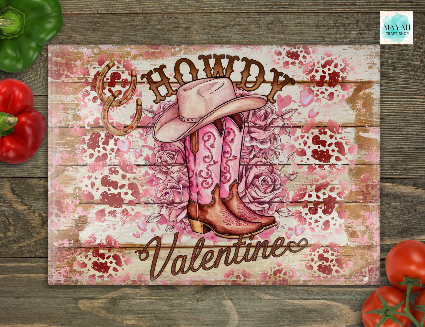 Valentine-themed cowboy design with pink boots, hat, and roses on a wooden background.