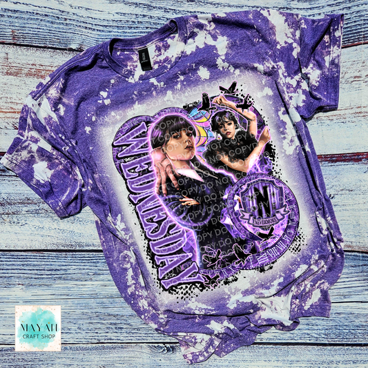 Purple scrounged t-shirt with graphic design on a wooden surface