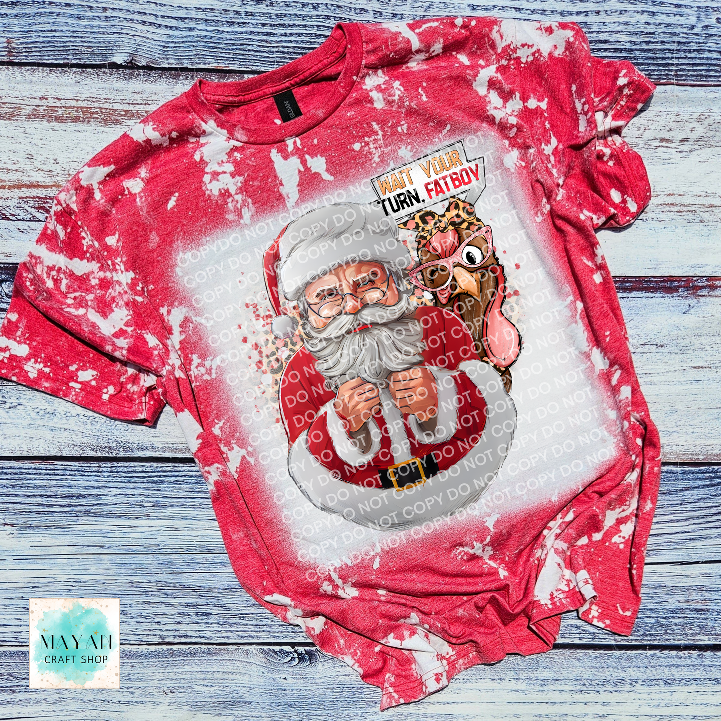 Red and white tie-dye shirt with a graphic of Santa Claus and a turkey on a wooden surface.