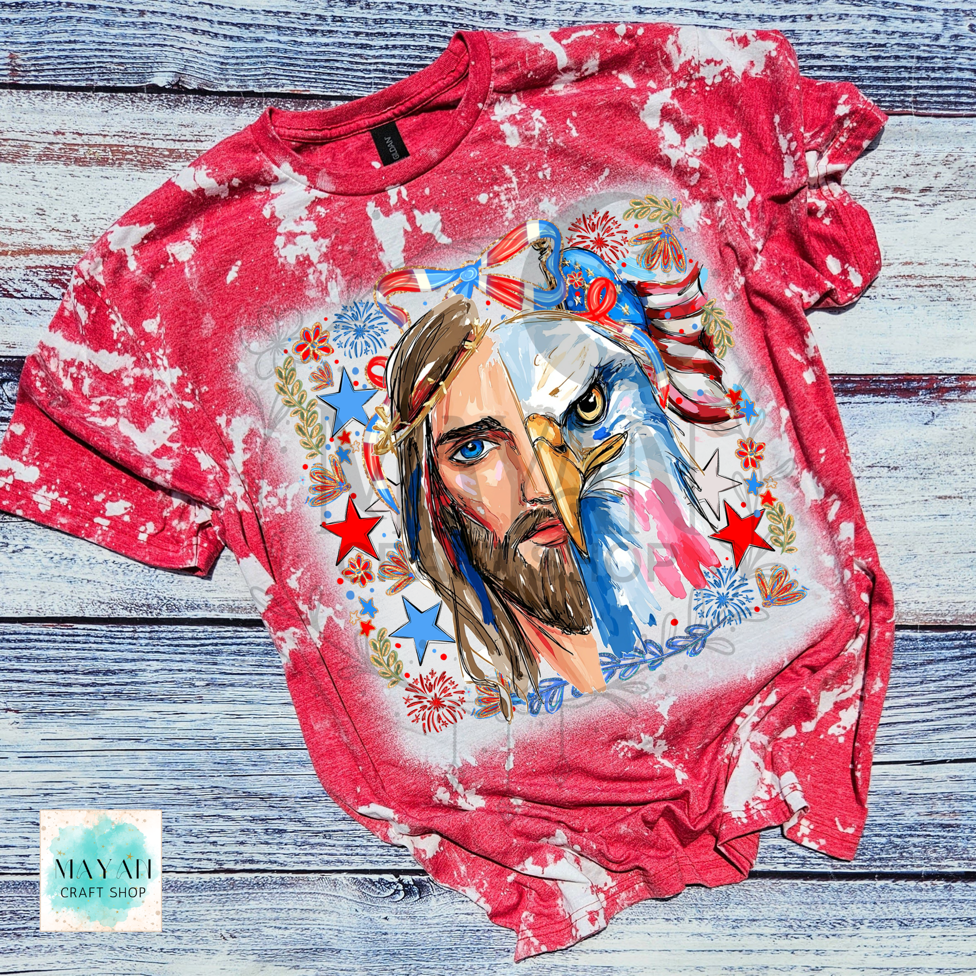 Red long-sleeve shirt with a graphic design of a man with an eagle head on a wooden surface.