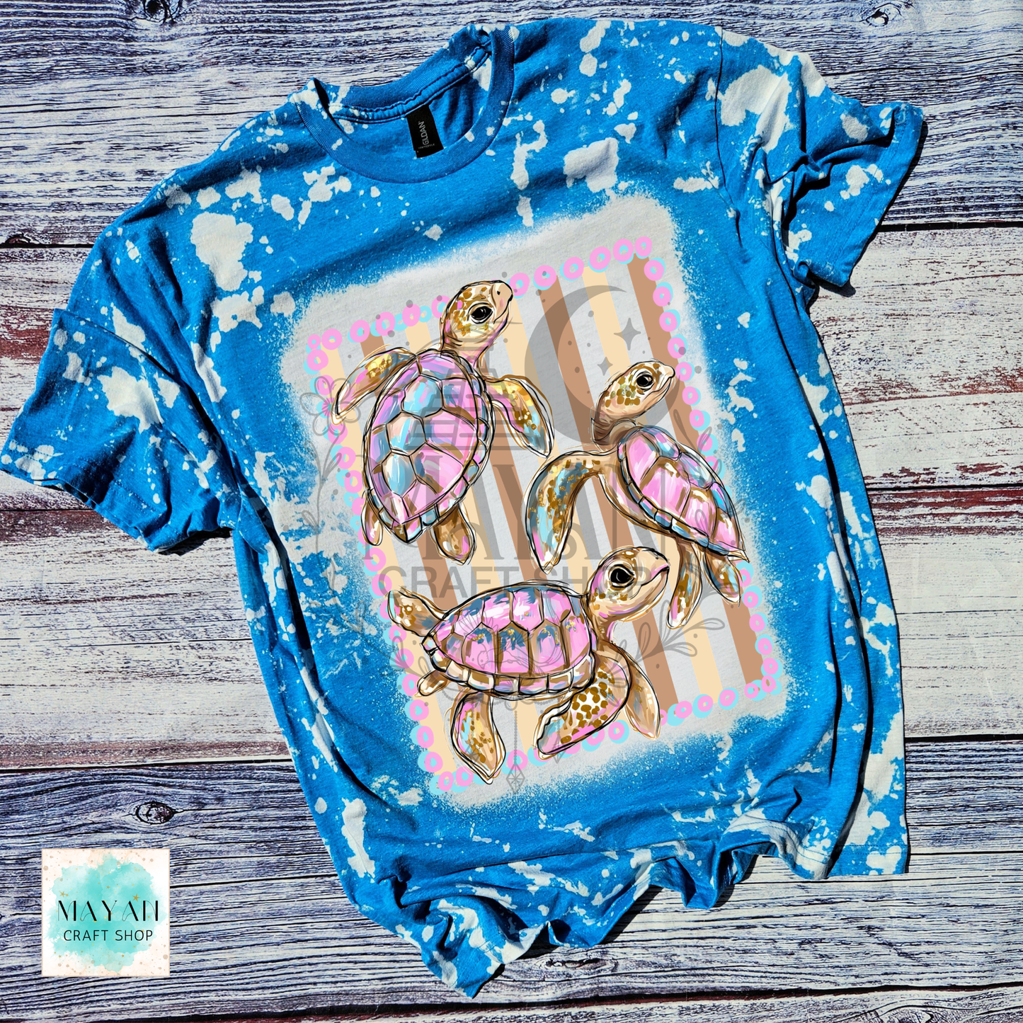 Blue bleached t-shirt with sea turtle design on a wooden surface