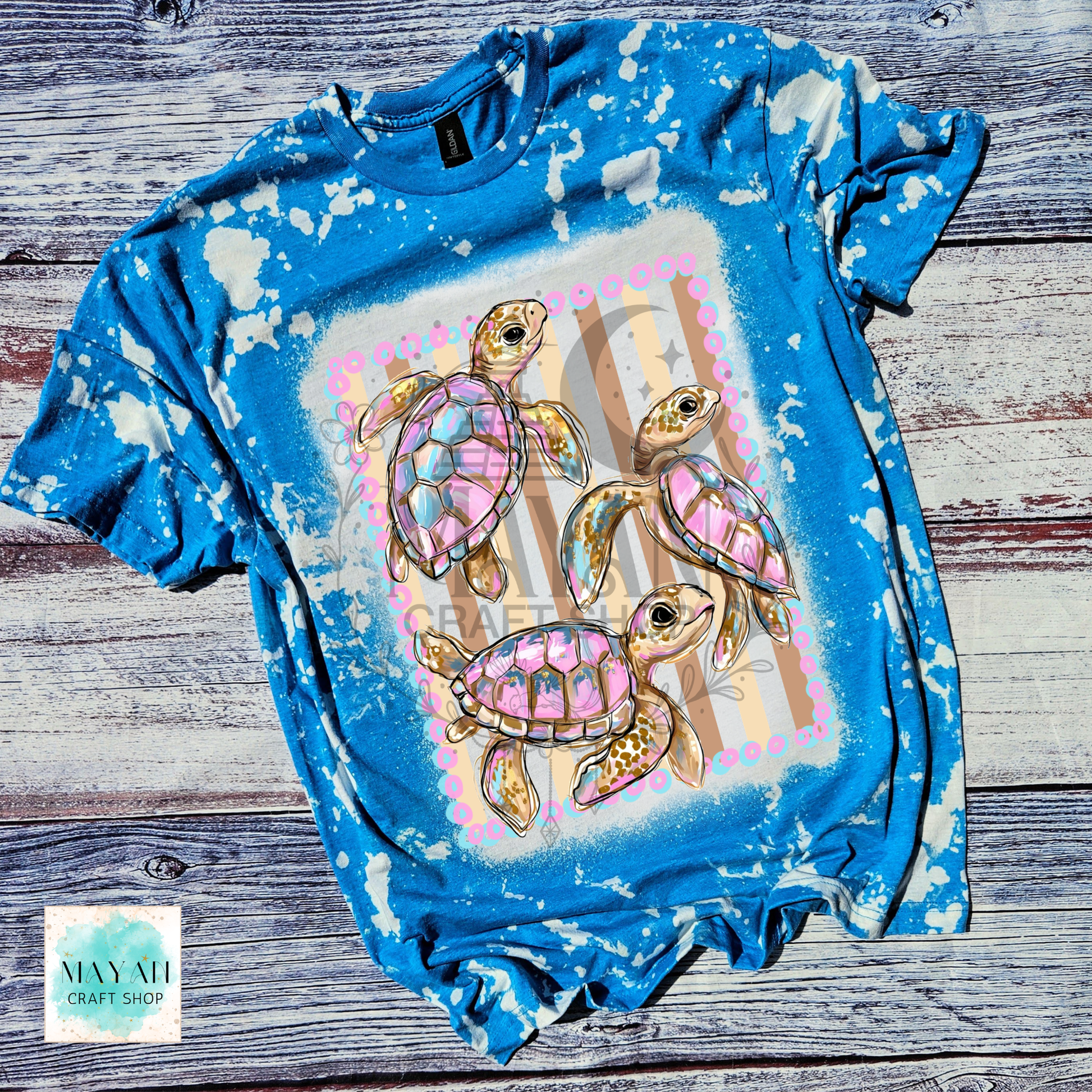 Blue bleached t-shirt with sea turtle design on a wooden surface