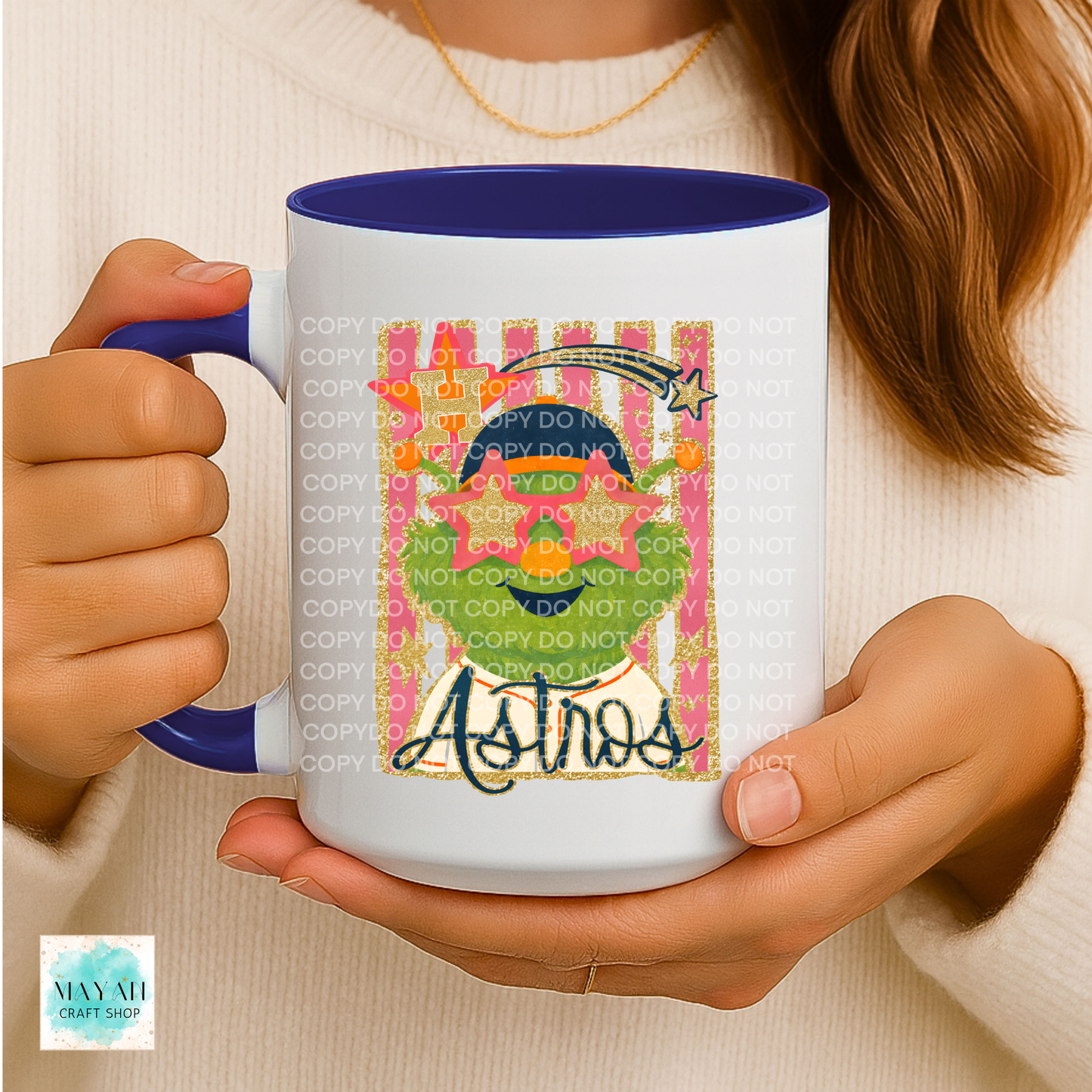 Person holding a mug with a colorful design and text, wearing a beige sweater.