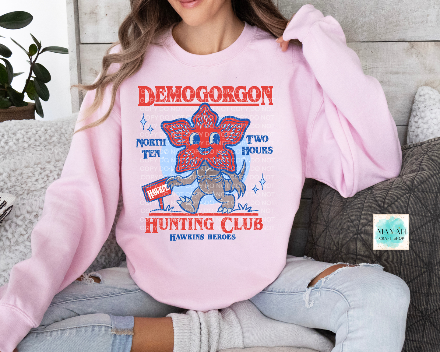 Person wearing a pink sweatshirt with 'Hunting Club' graphic design.