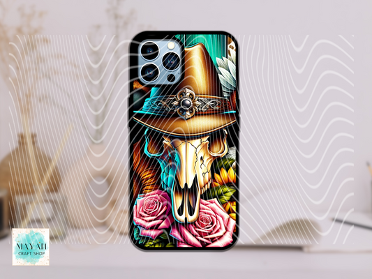Phone case with a design of a cow skull wearing a hat, surrounded by roses, on a light background.