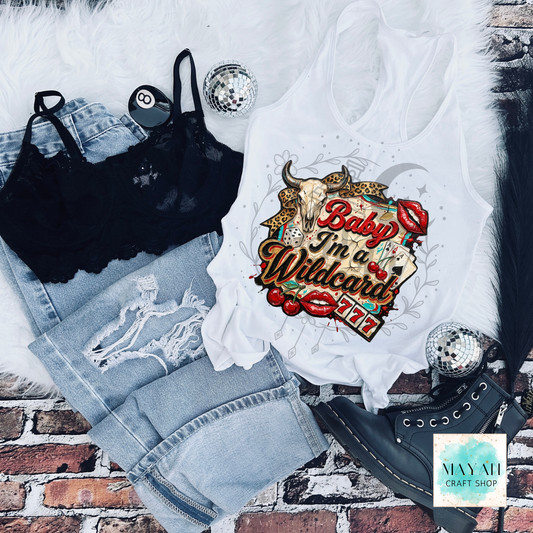 White tank top with graphic design, black bralette, denim shorts, and black high-heeled shoes on a brick surface.