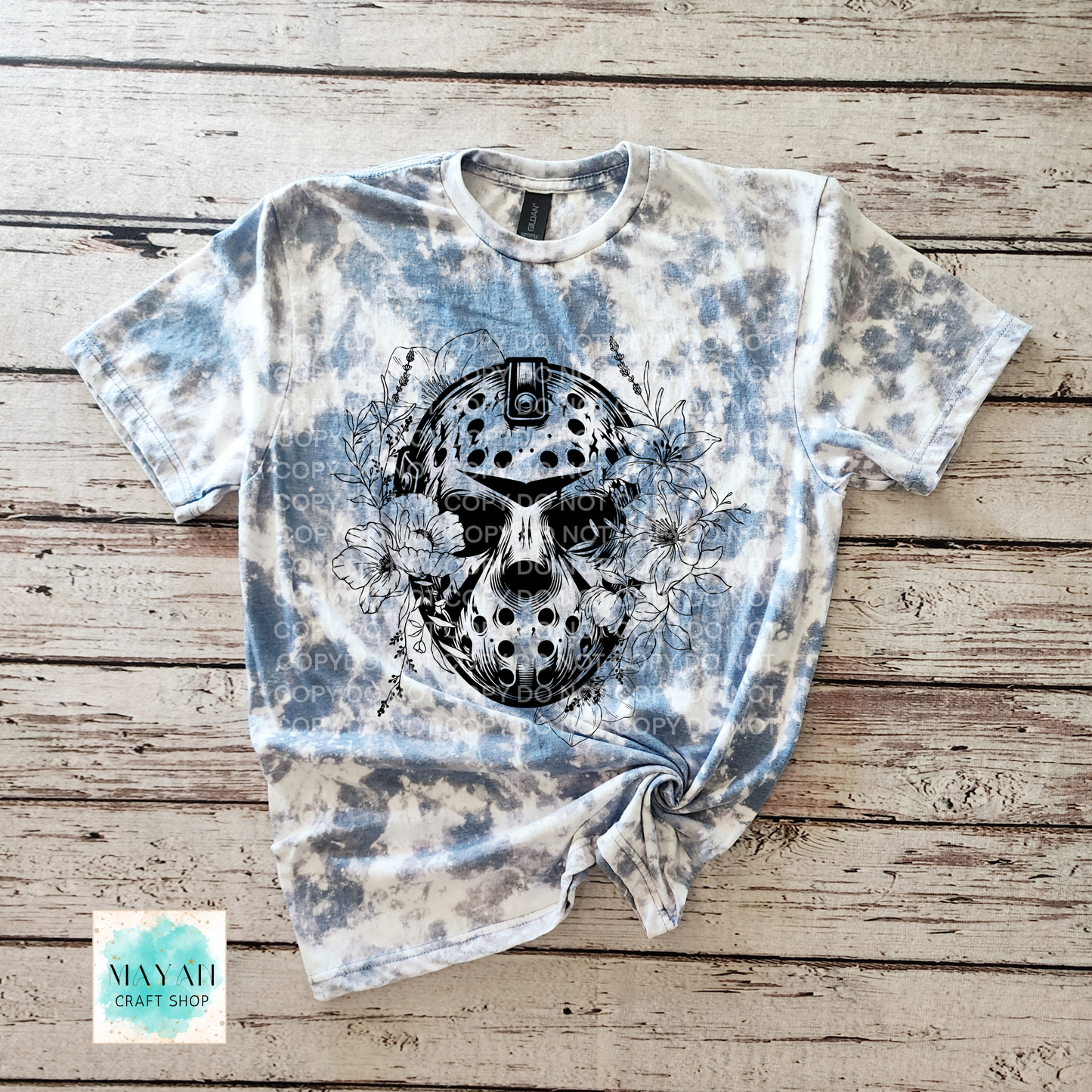 Tie-dye t-shirt with skull design on a wooden surface, featuring the brand 'Mayah Craft Shop'.