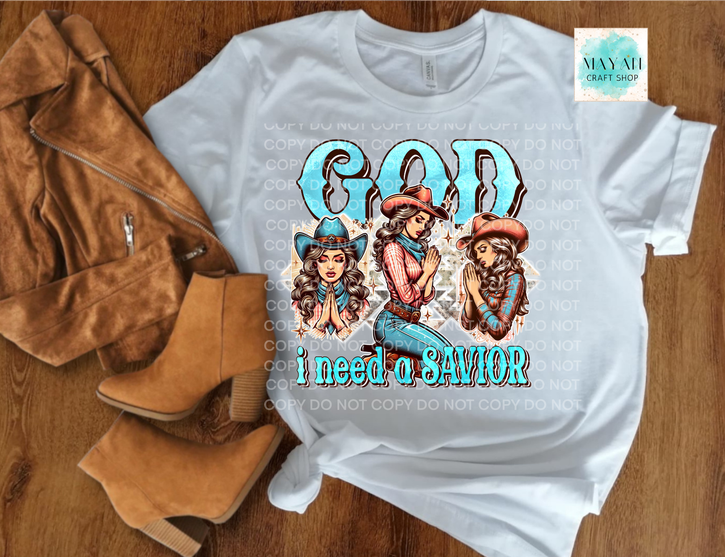 White t-shirt with graphic design and text on a wooden surface with boots and jacket.