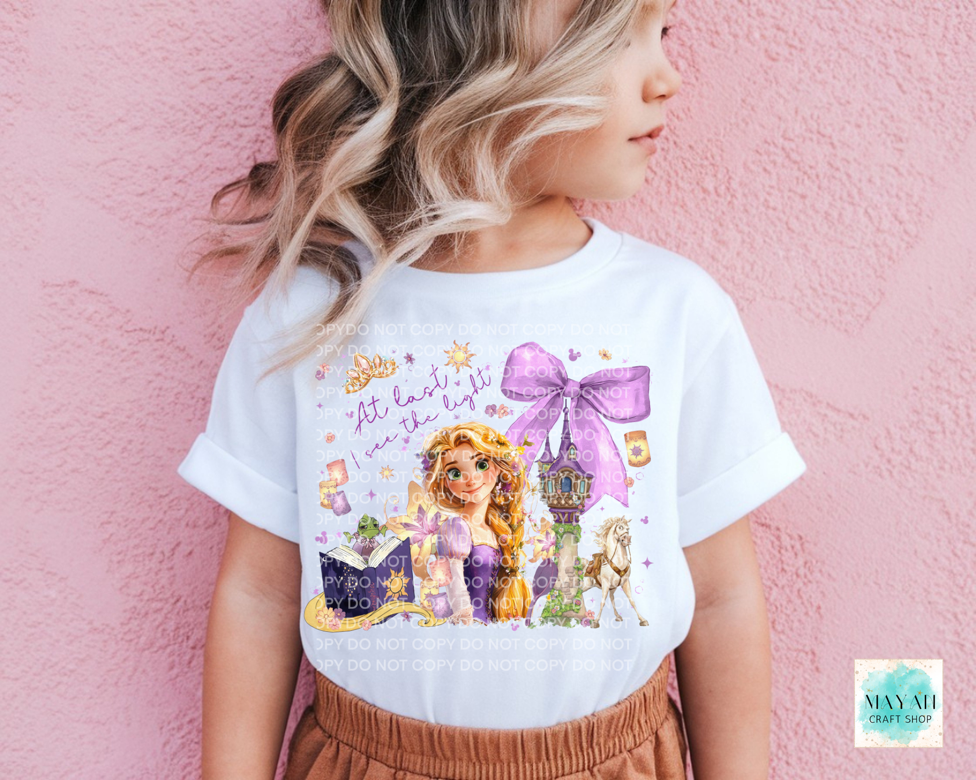 Child wearing a white t-shirt with a princess graphic design against a pink background