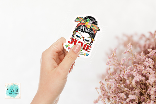 Hand holding a colorful sticker with text and graphics on a white background