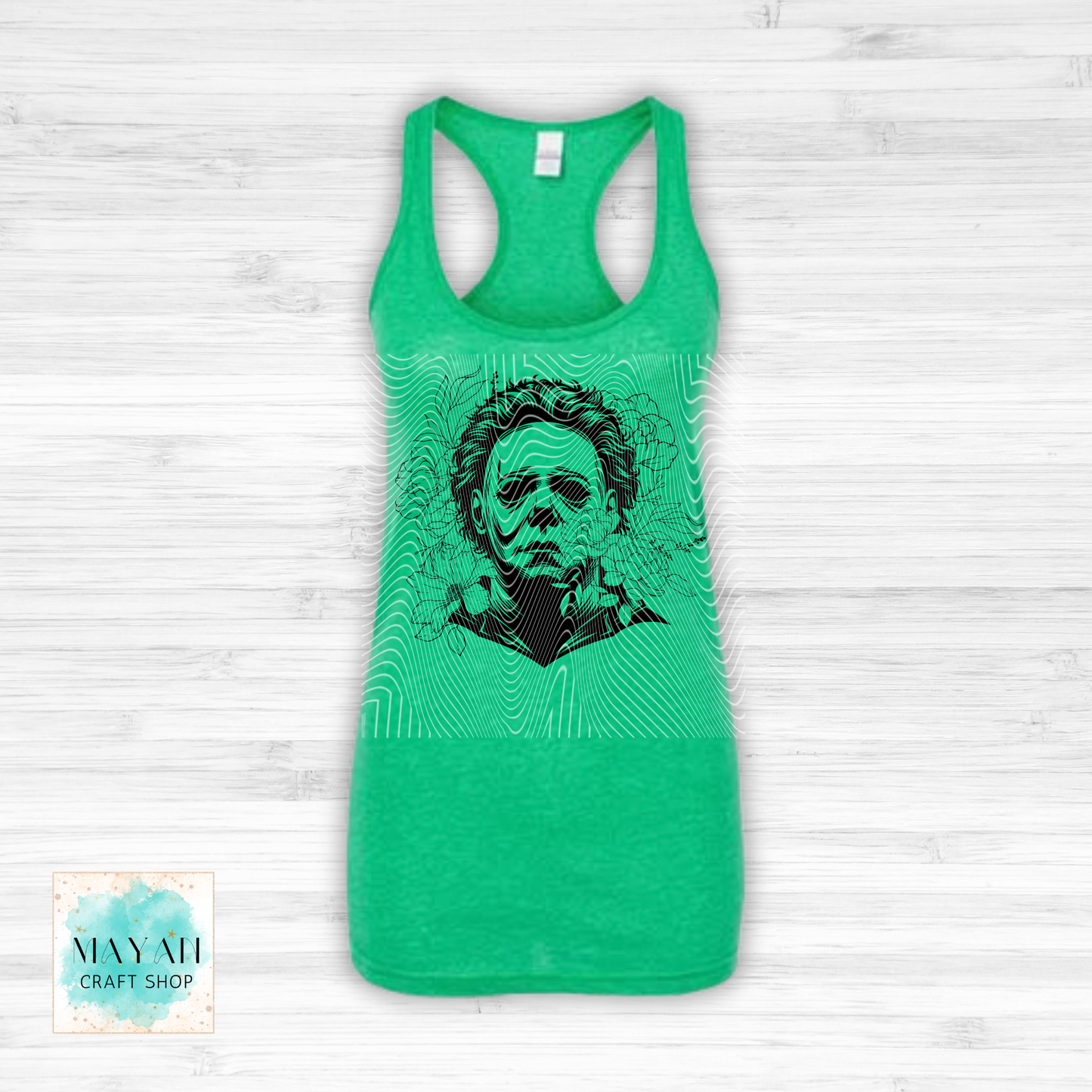 Green tank top with a graphic design on a light wooden surface.