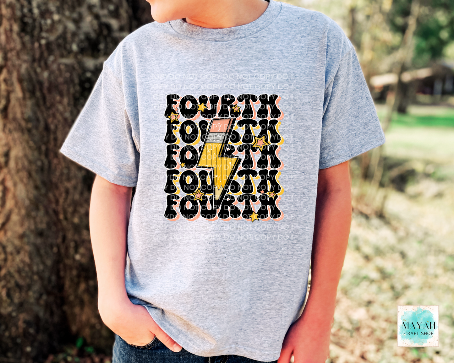 Child wearing a gray t-shirt with 'FOURTH' printed multiple times, outdoors.