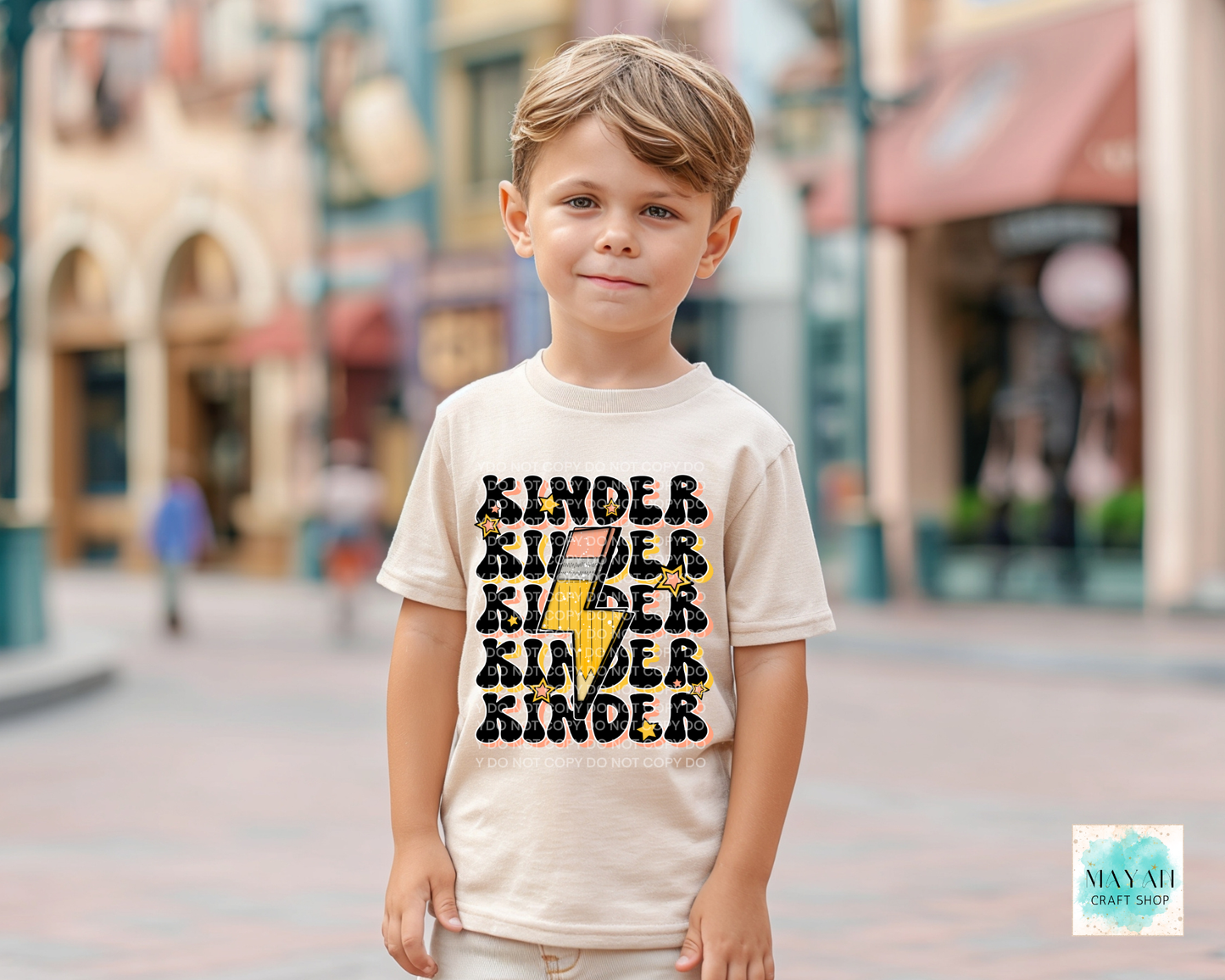 Child wearing a shirt with 'Kinder' text in an urban setting