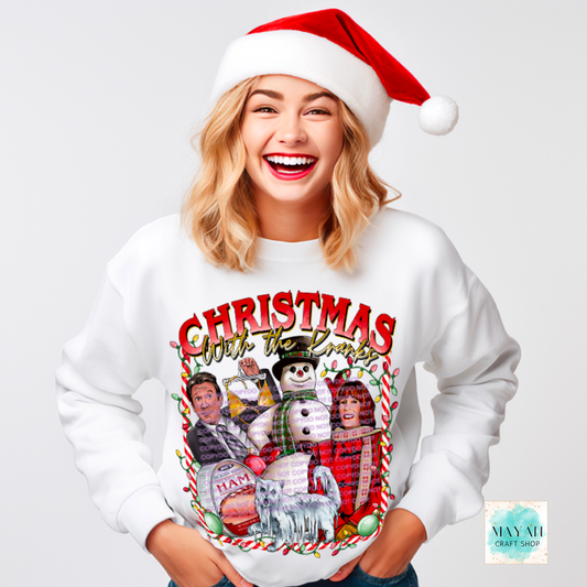 Person wearing a Christmas-themed sweatshirt with a snowman and holiday design, smiling against a white background.