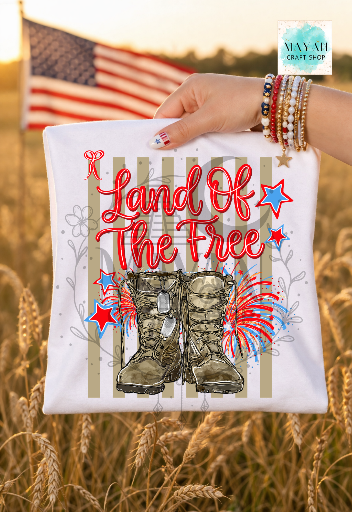 T-shirt with 'Land of the Free' text and boots design held in front of an American flag in a field.
