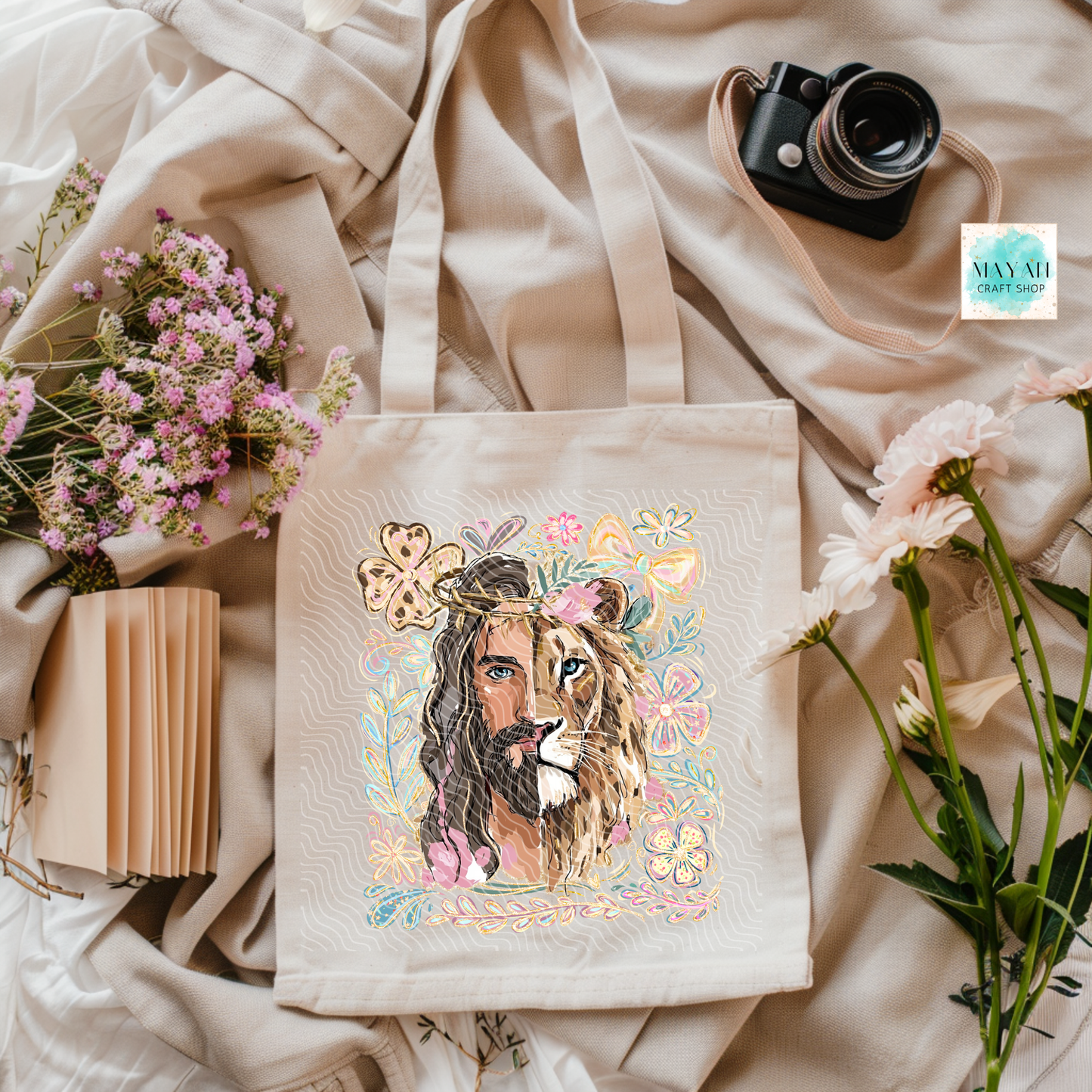 Tote bag with a design of a man with a lion's head and floral elements, surrounded by flowers and a camera.