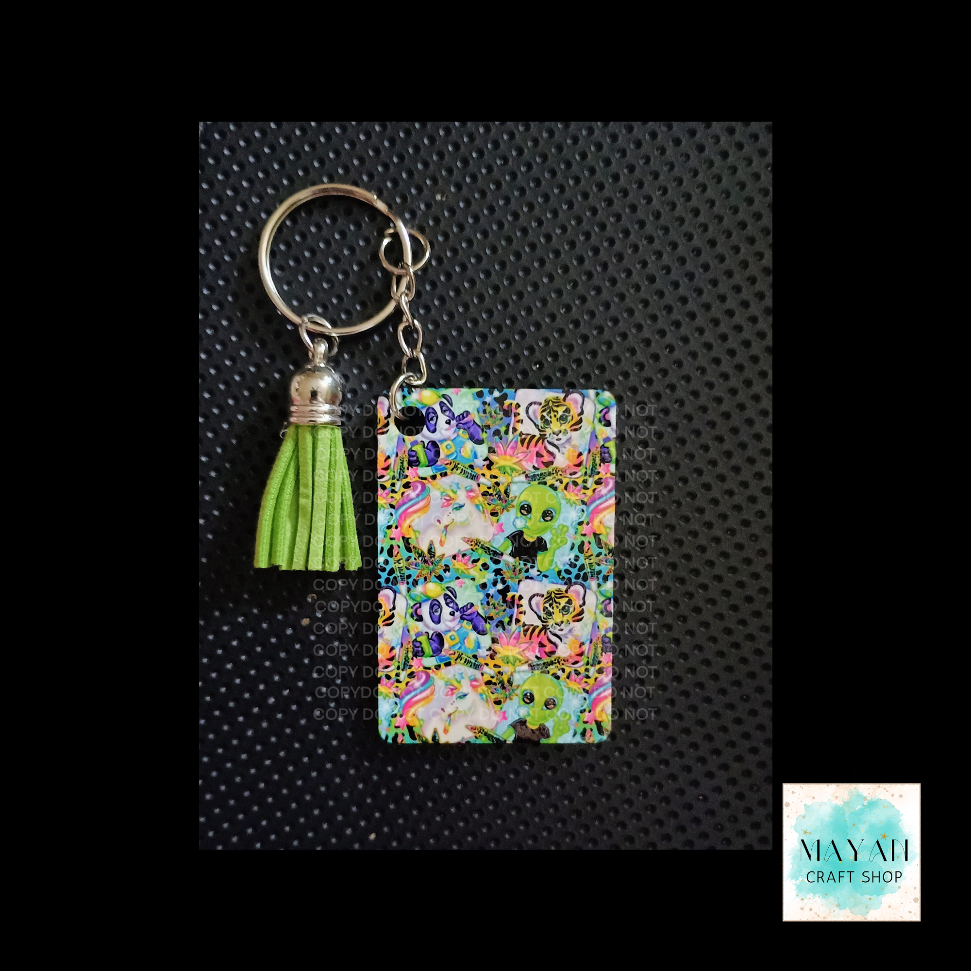 Colorful keychain with tassel and floral design on a black textured background