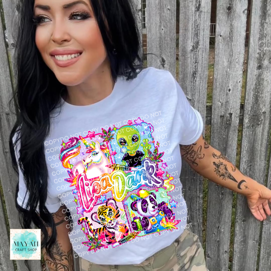 Woman wearing a colorful graphic t-shirt with cartoon characters against a wooden fence.