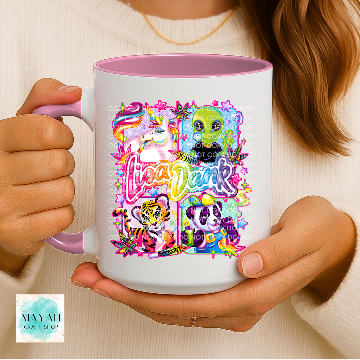 Person holding a mug with colorful designs and text.