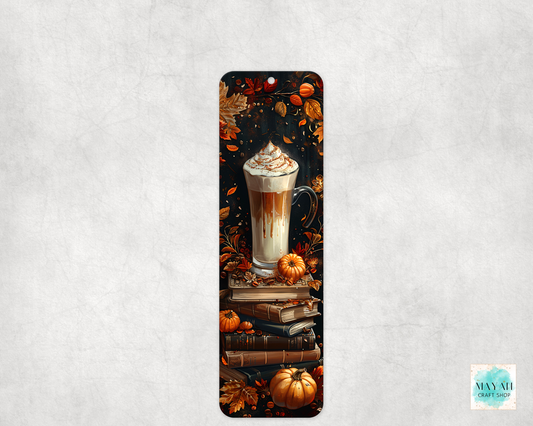 Bookmark with a design of a latte, pumpkins, and books on a textured gray background