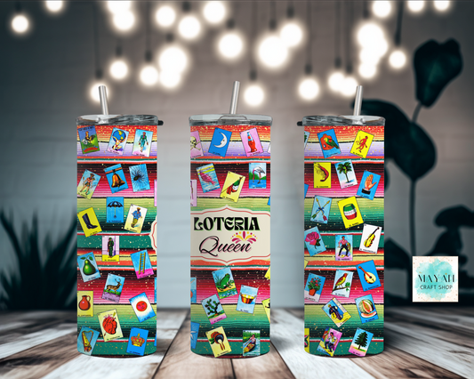 Three colorful tumblers with 'Loteria Queen' design on a wooden surface with blurred lights in the background.