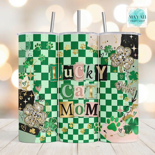 Three green checkered tumblers with decorative elements on a wooden surface.