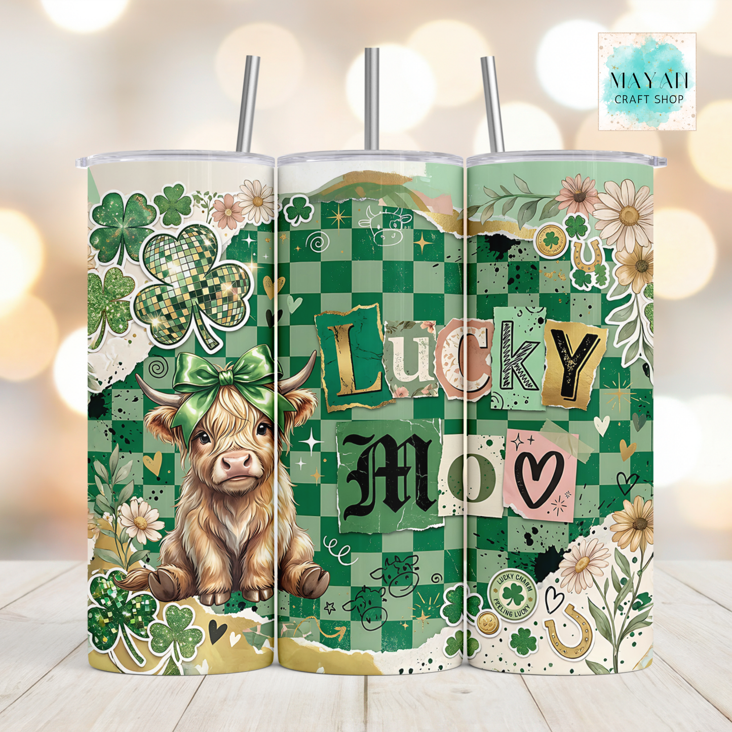 Three green-themed tumblers with a cow, shamrocks, and 'Lucky Mom' text on a wooden surface.