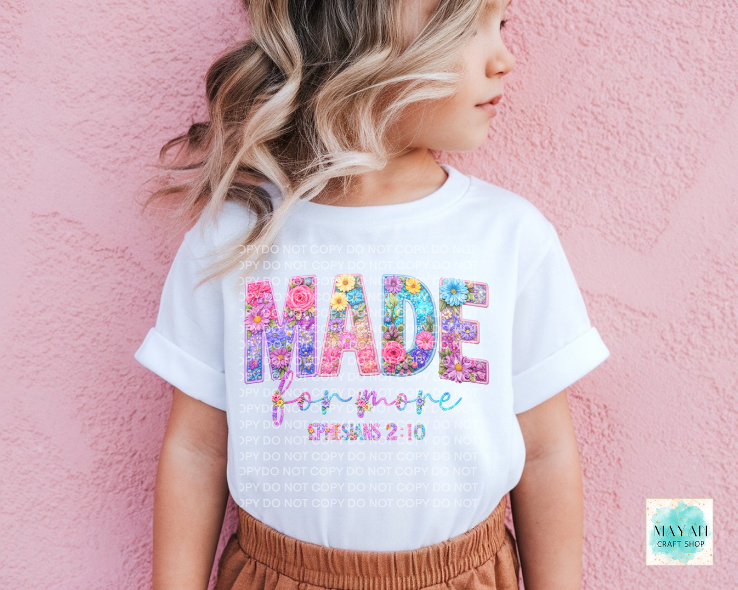 Child wearing a white t-shirt with colorful text against a pink background