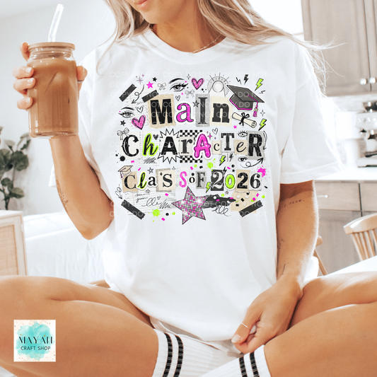 Person wearing a 'Main Character Class of 2026' t-shirt, holding a drink.