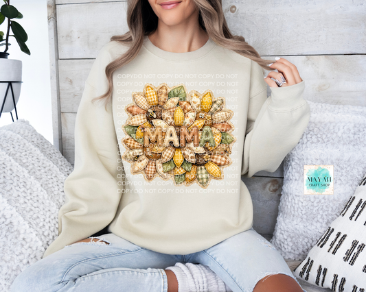 Person wearing a cream-colored sweatshirt with a colorful 'MAMA' design sitting on a couch.