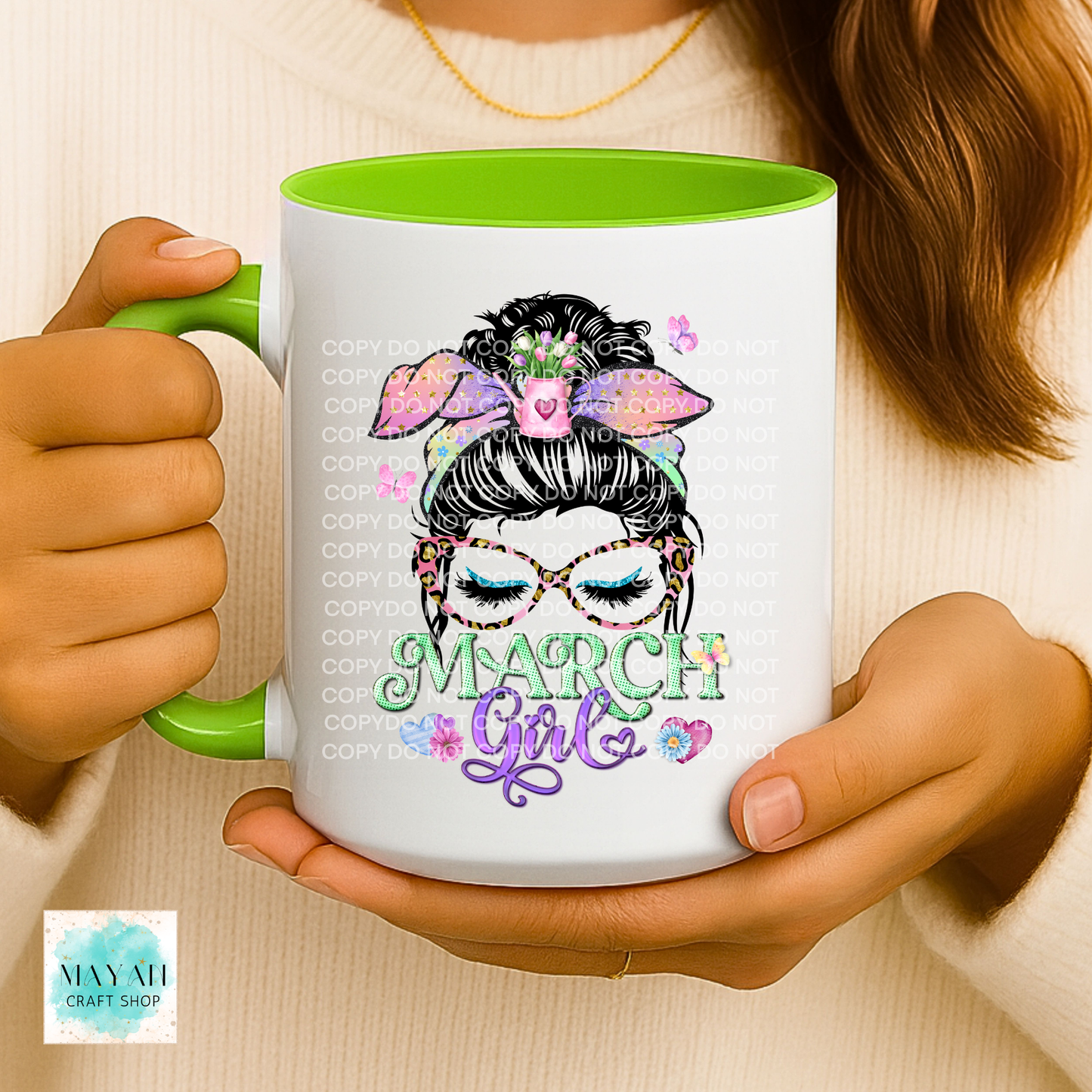 Person holding a mug with a design of a girl with a bun, glasses, and 'March Girl' text.