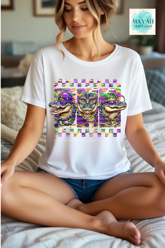 Woman wearing a white t-shirt with a colorful graphic design sitting on a bed.