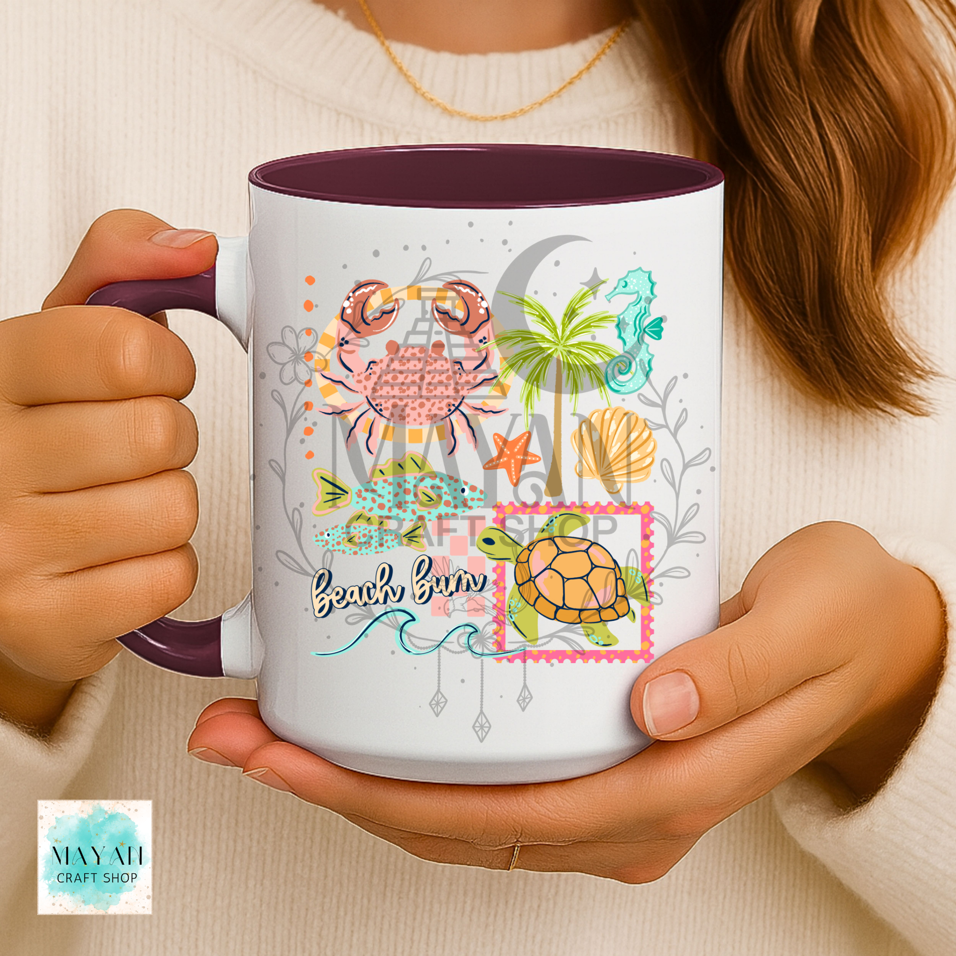Person holding a mug with beach-themed design featuring a turtle, palm tree, and seashells.