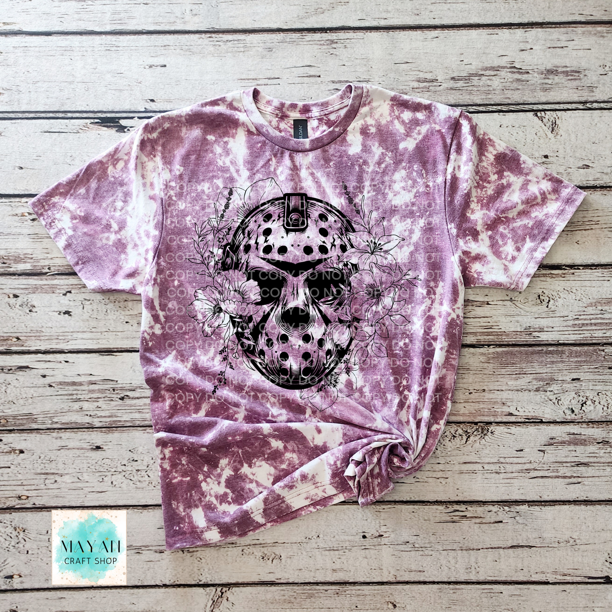 Tie-dye t-shirt with a black and white graphic design on a wooden surface.