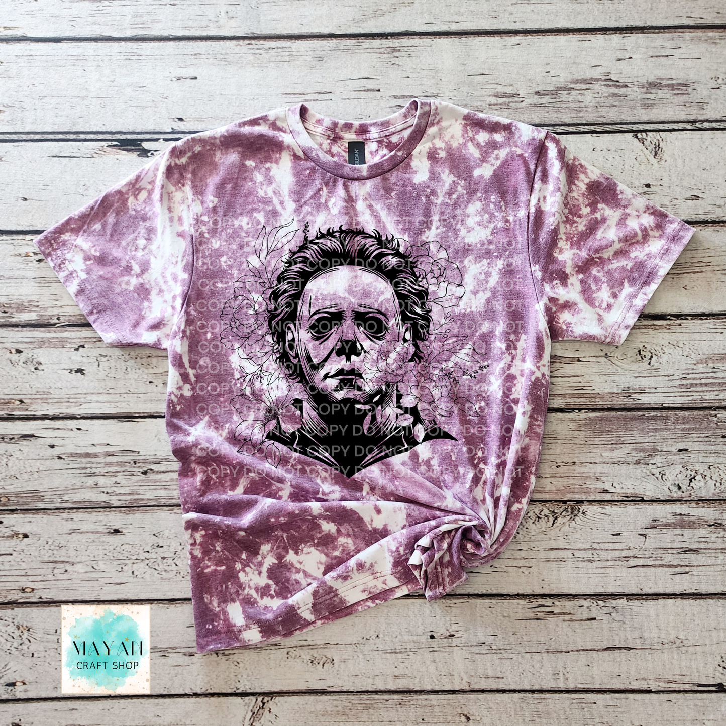 Marron bleached t-shirt with a graphic design on a wooden surface, featuring a brand logo in the corner.