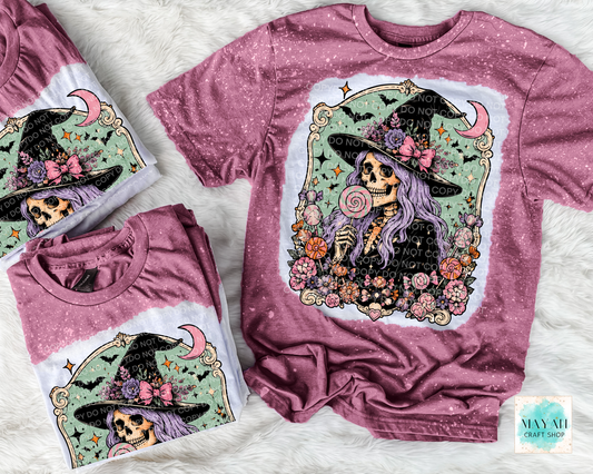 Maroon t-shirt with skeleton and floral design on a textured surface