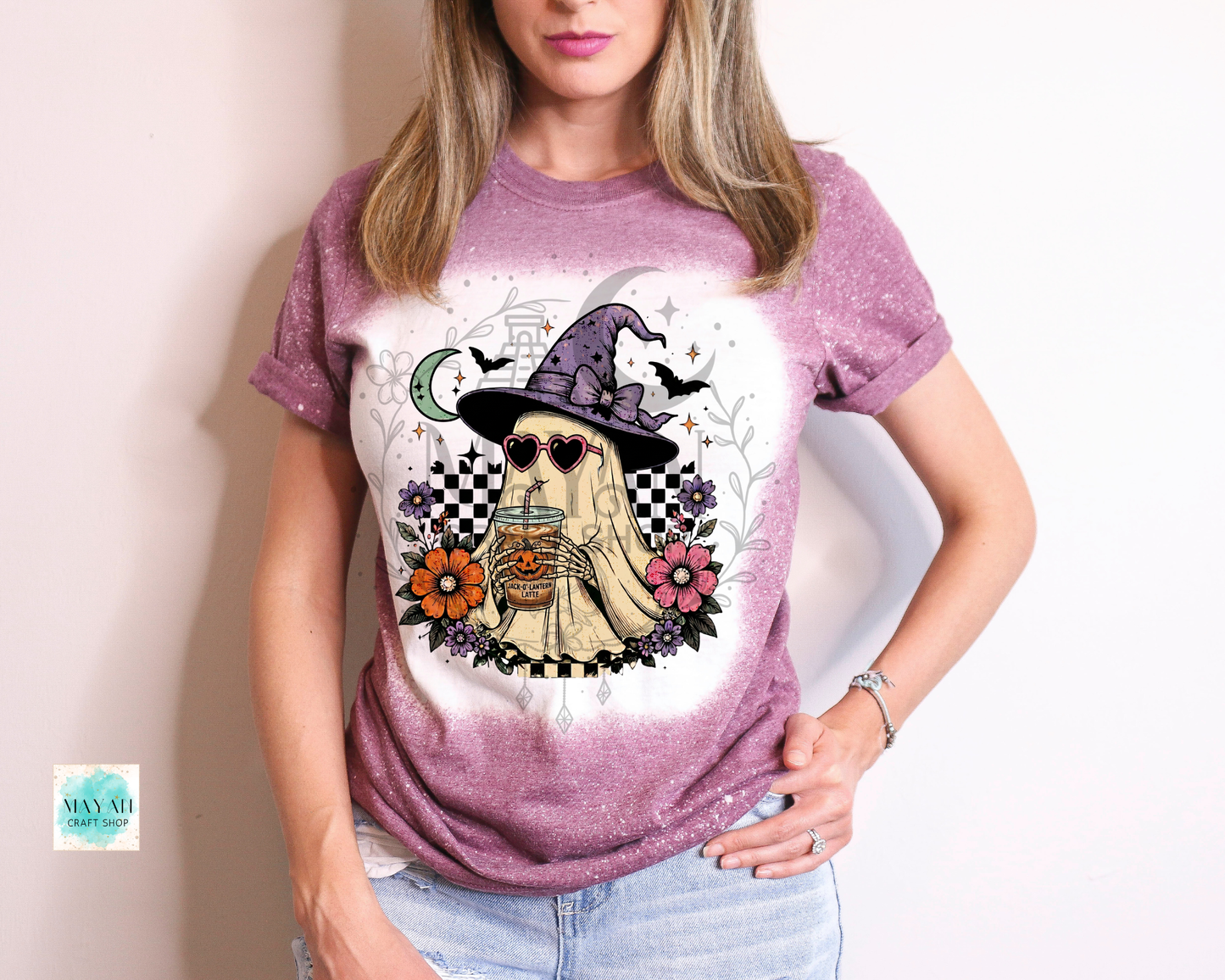 Person wearing a t-shirt with a graphic design of a ghost in a witch hat and sunglasses.