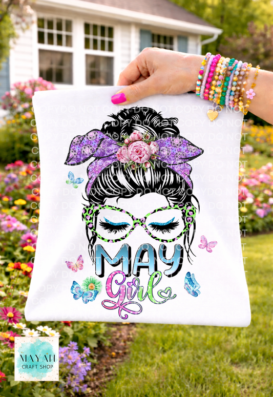 Shirt with 'May Girl' design held by a person outdoors.